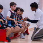 Harbor Sports Academy coach greeting young players courtside after a match