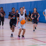Young Harbor Sports Academy player dribbling the ball during a mini basketball match