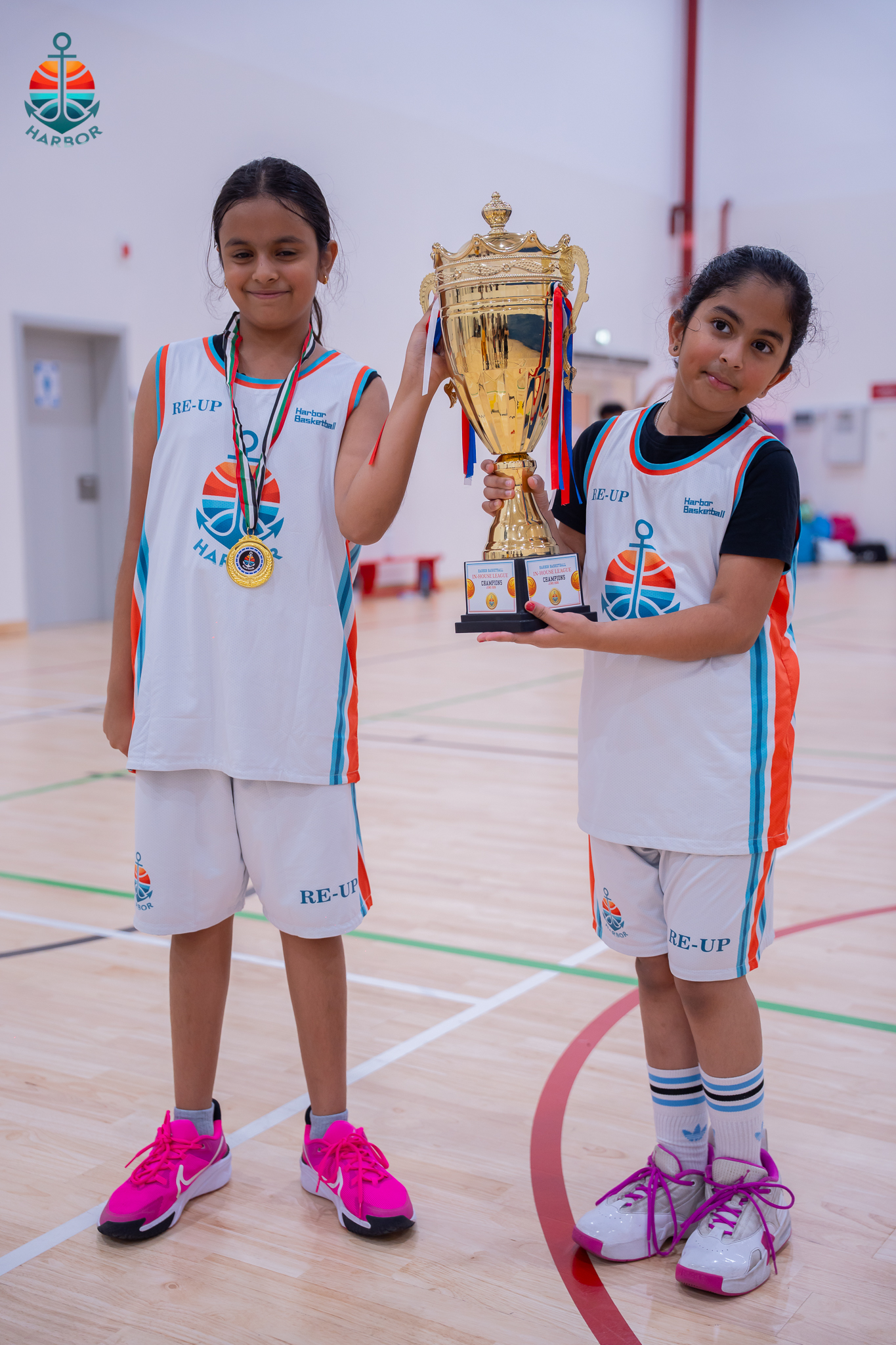 Harbor Sports Academy young athletes holding up their tournament trophy