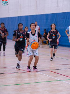 Young Harbor Sports Academy player dribbling the ball during a mini basketball match