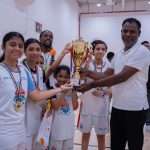 Harbor Sports Academy girls basketball team receiving their trophy from their coach
